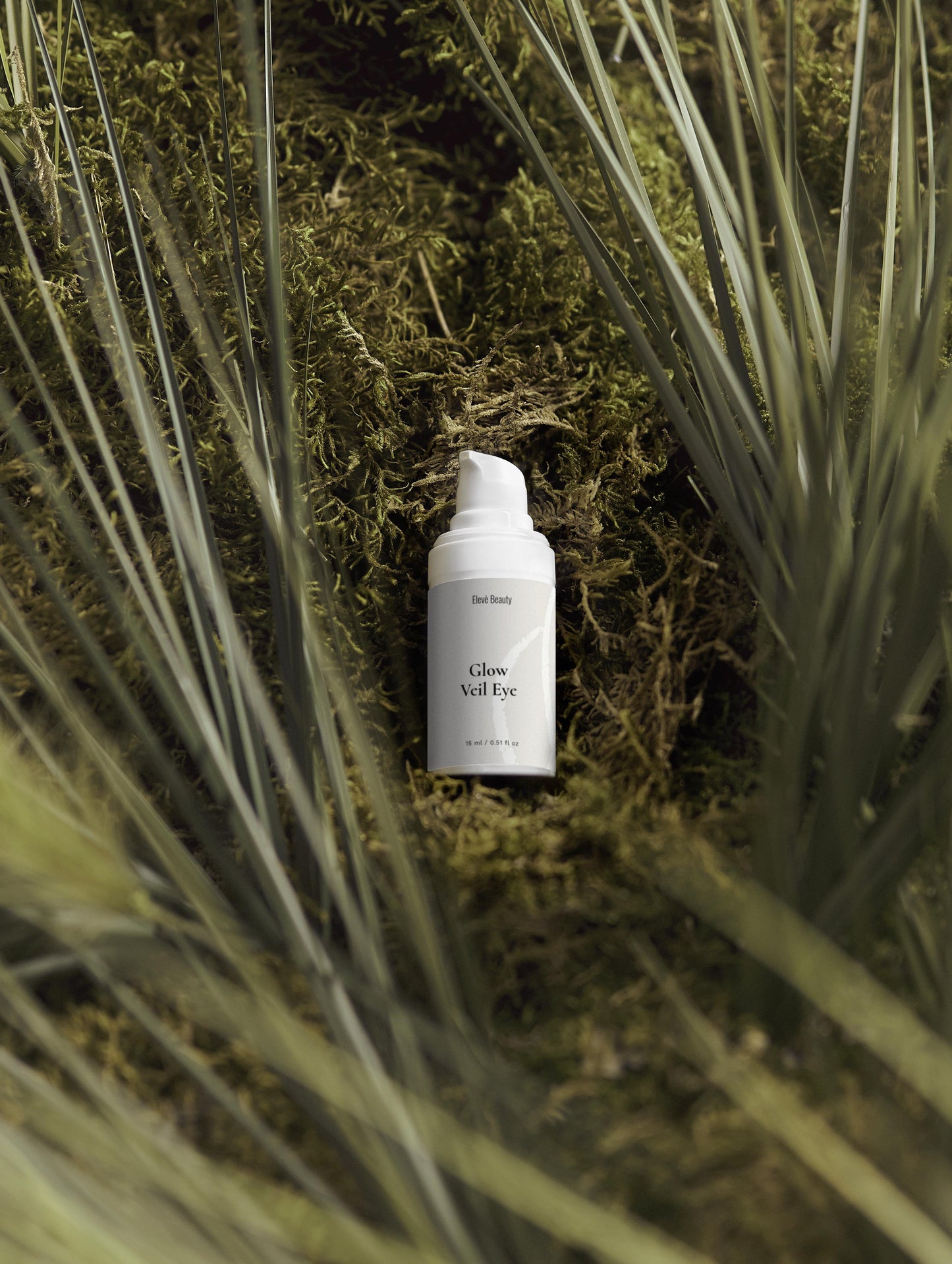 Glow Eye Serum liegt mitten im Gras.