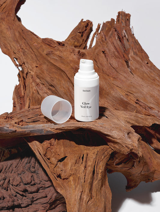 Glow Veil Eye Serum steht auf dekorativem Holz. 