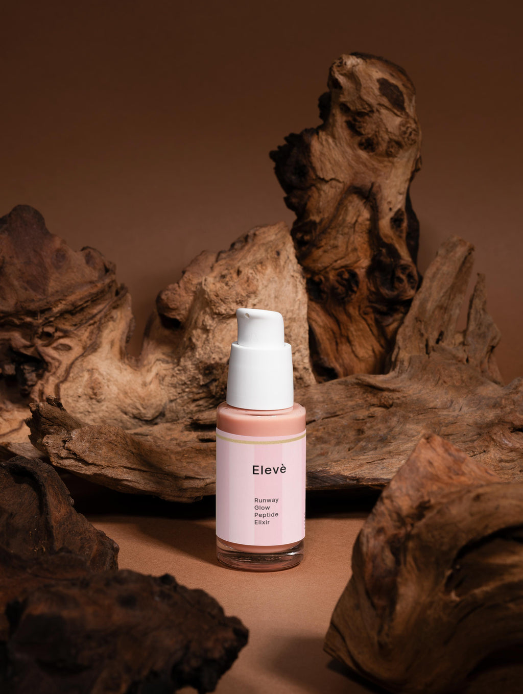 Elevè Peptide Serum Flakon Vorderseite ohne Verpackung vor braunem Holzhintergrund-luxuriöses Anti-Aging-Serum mit Peptiden, Hyaluronsäure und Ginko-Extrakt für glattere, straffere und sichtbar verfeinerte Haut. 